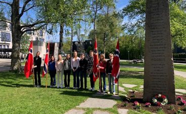 en gruppe mennesker som står foran en gravstein