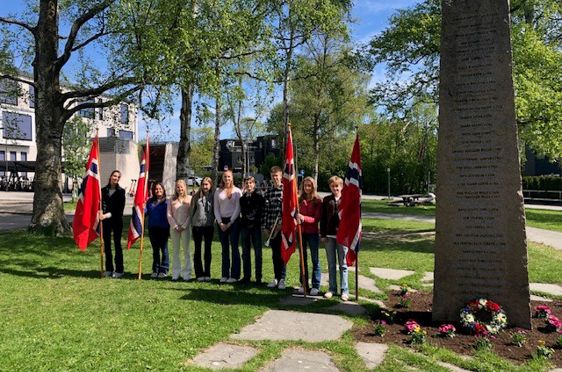 en gruppe mennesker som står foran en gravstein
