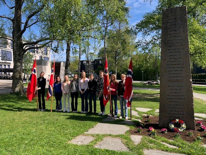 en gruppe mennesker som står foran en gravstein