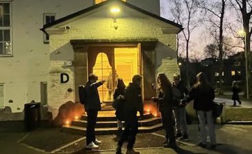 en gruppe mennesker som står utenfor et hus