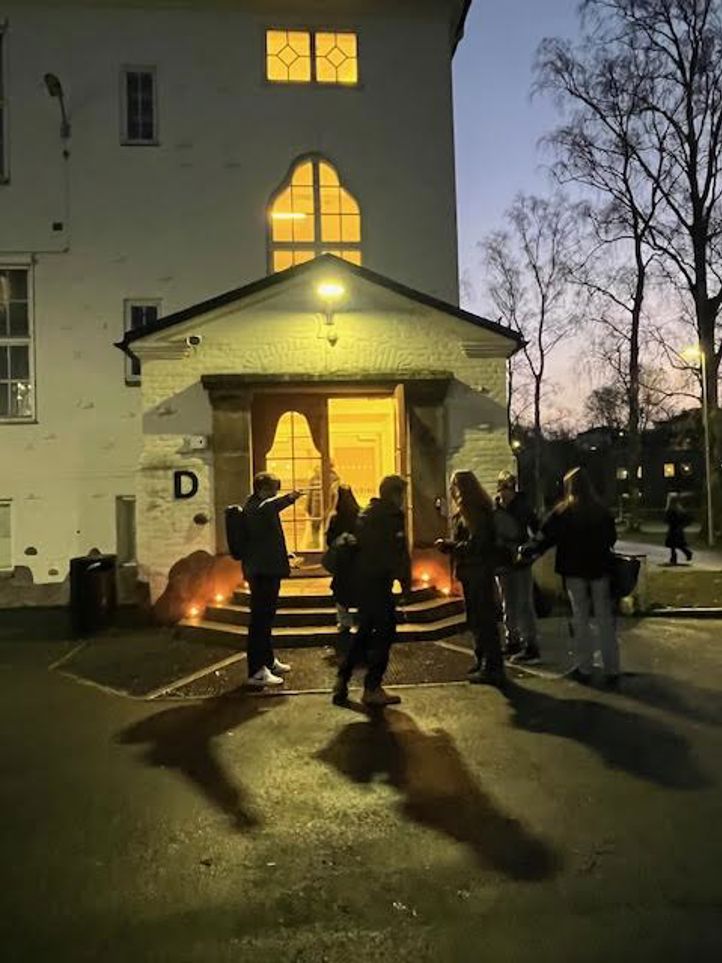 en gruppe mennesker som står utenfor et hus