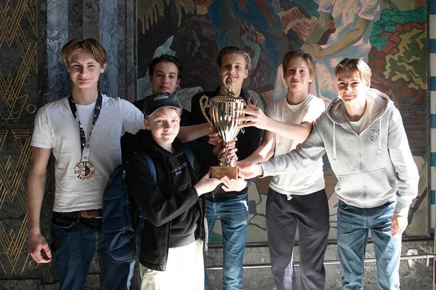 En gruppe mennesker poserer for et bilde med et trofé
